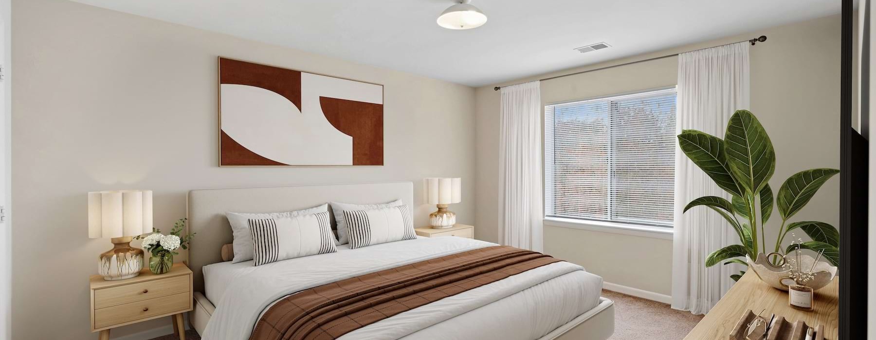 Spacious bedroom with large window and plant