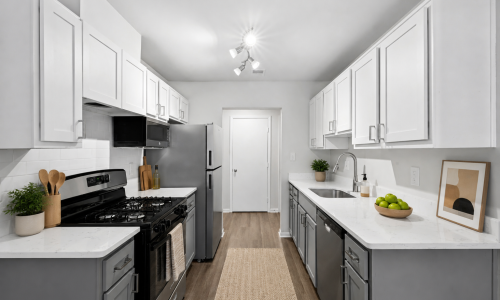 Kitchen with stainless steel appliances and white cabinets and countertops