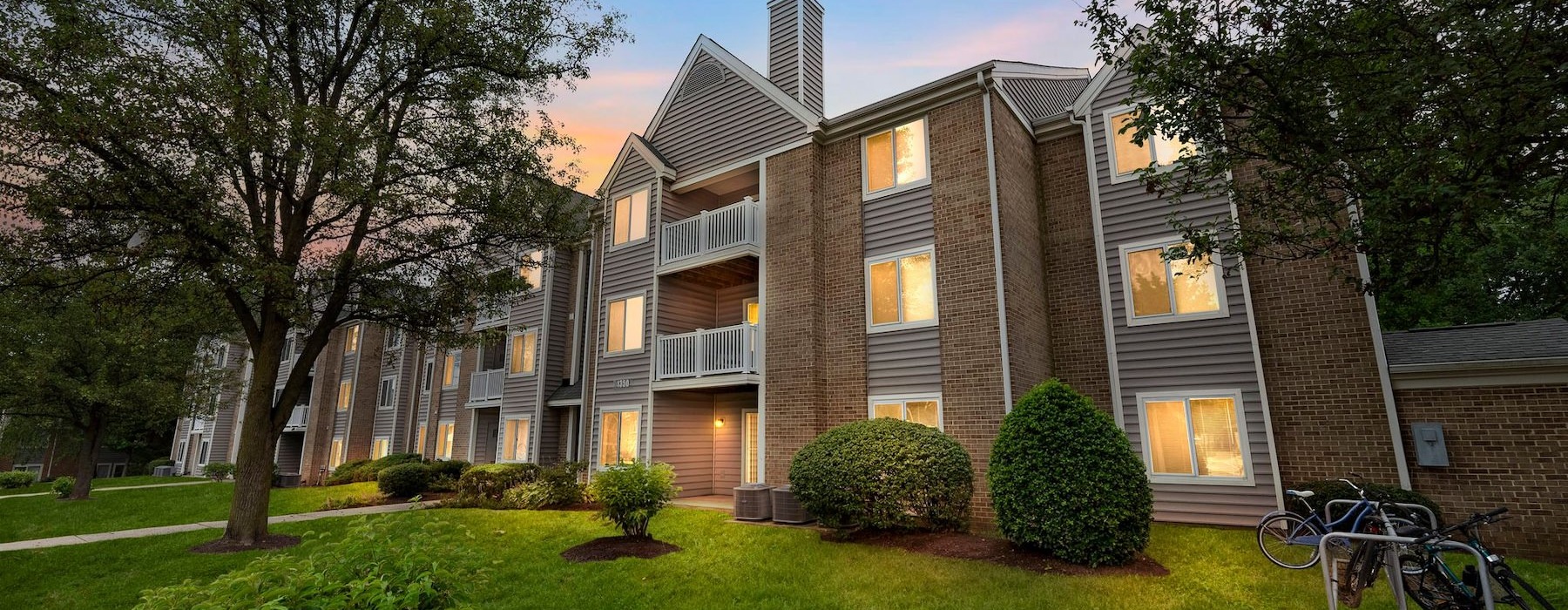 a large house with a lawn and trees in front of it