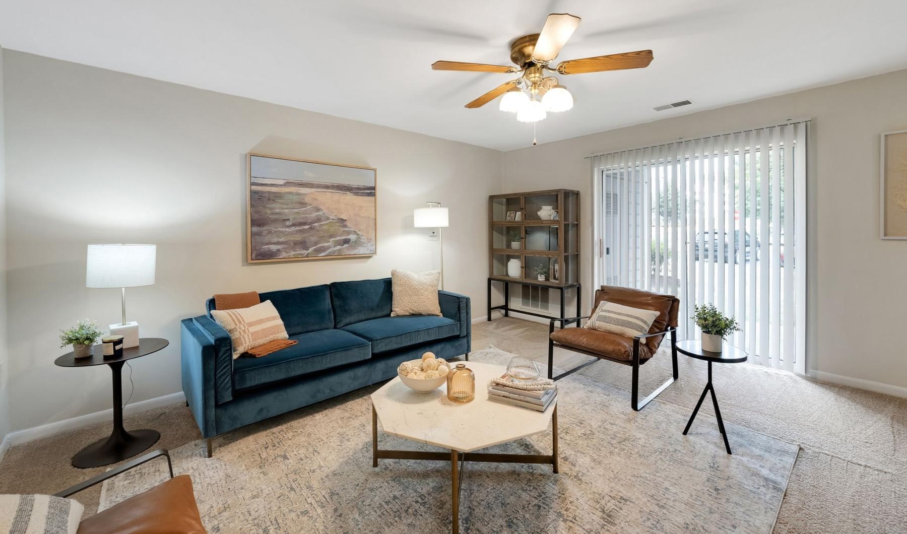 a living room with a blue couch and a ceiling fan